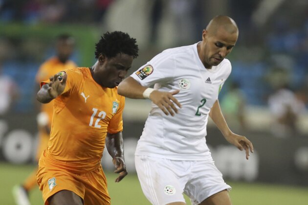 Ivory Coast's Wilfried Bony, Left, is tackled by Algeria's Madjid Bouguerra, Right, during their African Cup of Nations quarter final soccer match at the Estadio De Malabo, Equatorial Guinea, Sunday, Feb. 1, 2015. (AP Photo/Sunday Alamba)