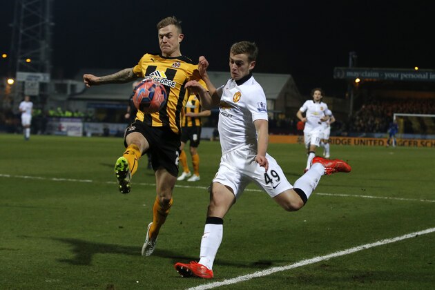 Manchester United’s James Wilson, right, goes to cross the ball under pressure from Cambridge United’s Richard Tait during their English FA Cup fourth round soccer match between Cambridge United and Manchester United, in Cambridge, England, Friday, Jan. 23, 2015. (AP Photo/Alastair Grant)