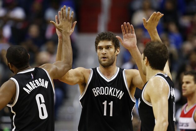 Brooklyn Nets guards Alan Anderson (6) and Bojan Bogdanovic (44), from Croatia, right, celebrate with center Brook Lopez (11) after a play in the second half of an NBA basketball game against the Washington Wizards, Friday, Jan. 16, 2015, in Washington. The Nets won 102-80.(AP Photo/Alex Brandon)