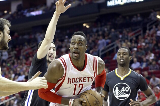 Houston Rockets' Dwight Howard (12) is surrounded by Golden State Warriors Andrew Bogut, left, Klay Thompson, and Harrison Barnes (40) in the second half of an NBA basketball game Saturday, Jan. 17, 2015, in Houston. The Warriors won. (AP Photo/Pat Sullivan)