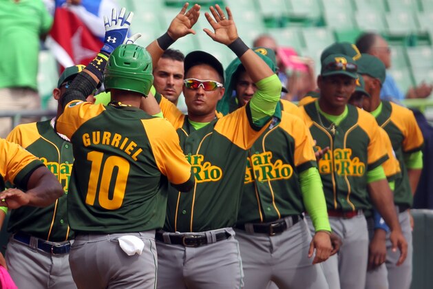 Cuba second baseman Yulieski Gurriel is congratulated by his teammates after scoring a run in a Caribbean Series baseball game against Mexico, in San Juan, Puerto Rico, Monday, Feb. 2, 2015. (AP Photo/Ricardo Arduengo)