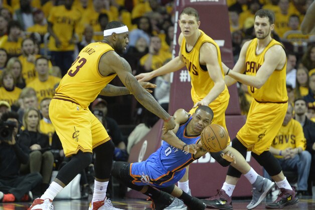 Jan 25, 2015; Cleveland, OH, USA; Oklahoma City Thunder guard Russell Westbrook (0) slips while guarded by Cleveland Cavaliers forward LeBron James (23), center Timofey Mozgov (20) and forward Kevin Love (0) in the third quarter at Quicken Loans Arena. Mandatory Credit: David Richard-USA TODAY Sports