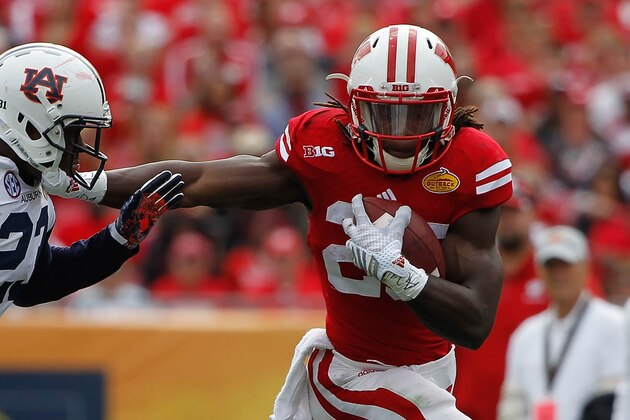 Jan 1, 2015; Tampa, FL, USA; Wisconsin Badgers running back Melvin Gordon (25) stiff arms Auburn Tigers defensive back Johnathan Ford (23) during the first half in the 2015 Outback Bowl at Raymond James Stadium. Mandatory Credit: Kim Klement-USA TODAY Sports