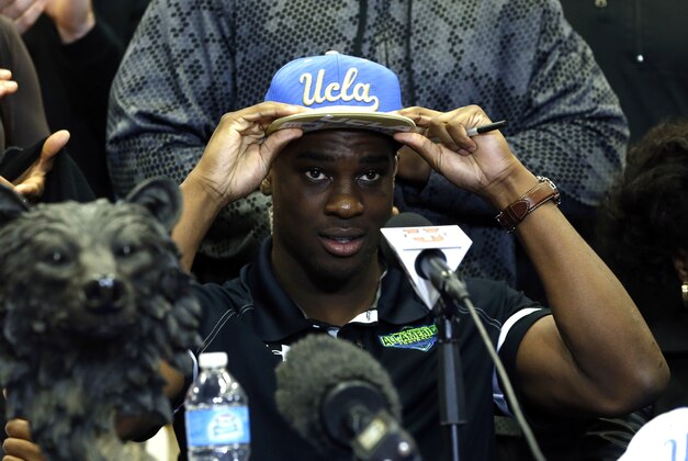 Feb 4, 2015; Plano, TX, USA; SoSo Jamabo puts on a UCLA Bruins hat after announcing he sign with them at Plano West High School. Mandatory Credit: Tim Heitman-USA TODAY Sports