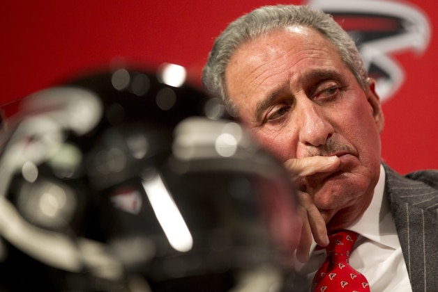 Atlanta Falcons owner Arthur Blank looks on during a news conference introducing former Seattle Seahawks defensive coordinator Dan Quinn as the NFL football team's new head coach, Tuesday, Feb. 3, 2015, in Flowery Branch, Ga. After the news conference Blank responded to the NFL’s investigation there was fake crowd noise pumped into home games. He said “what we’ve done in 2013 and 2014 was wrong” and said he expects results of the league’s investigation in a few weeks. The Falcons could be fined or penalized with the loss of a draft pick by the league.  (AP Photo/John Bazemore)