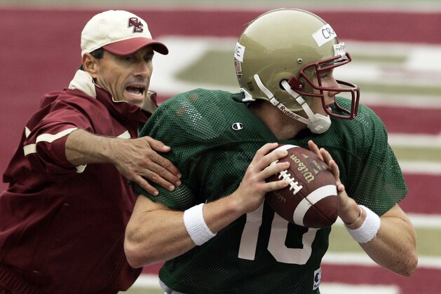 Boston College offensive coordinator Steve Logan grabs at quarterback Chris Crane (10) during a drill at practice for the football team during media day at the campus in Boston on Friday, Aug. 10, 2007. (AP Photo/Elise Amendola)