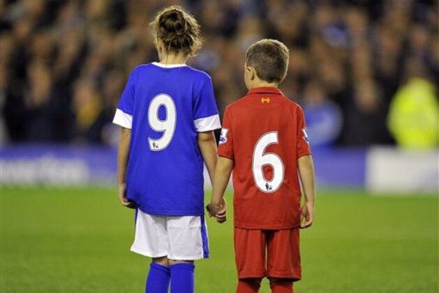 Two Everton mascots, one wearing a Liverpool FC kit stand in the centre circle in a minute's applause in recognition of the 96 Liverpool fans that died at Hillsborough disaster during their English Premier League soccer match at Goodison Park in Liverpool, England, Monday Sept. 17, 2012. (AP Photo/Clint Hughes)