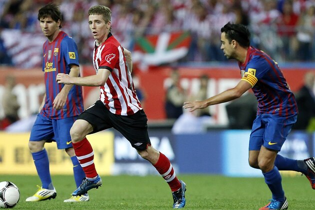 MADRID, SPAIN - MAY 25: Iker Muniain of Athletic Bilbao runs with the ball beside Xavi Hernandez (R) and Lionel Messi of Barcelona during the Copa del Rey Final match between Athletic Bilbao and Barcelona at Vicente Calderon Stadium on May 25, 2012 in Madrid, Spain. (Photo by Angel Martinez/Getty Images)