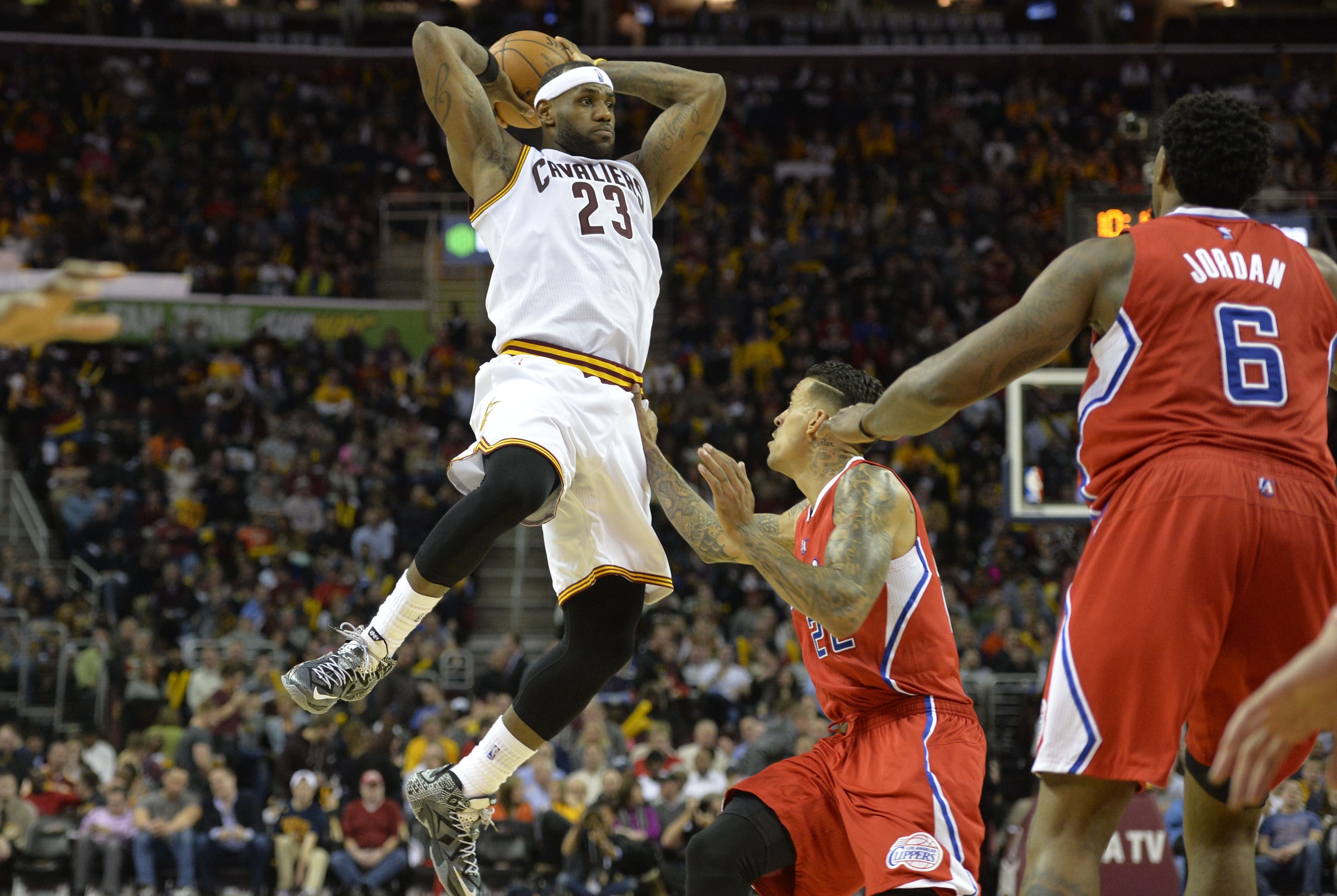 Feb 5, 2015; Cleveland, OH, USA; Cleveland Cavaliers forward LeBron James (23) passes against Los Angeles Clippers forward Matt Barnes (22) and center DeAndre Jordan (6) in the third quarter at Quicken Loans Arena. Mandatory Credit: David Richard-USA TODAY Sports