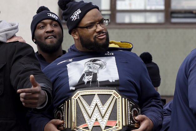 New England Patriots defensive lineman Alan Branch, center, wears a WWE belt during a victory parade in Boston Wednesday, Feb. 4, 2015, held to honor the team after defeating the Seattle Seahawks 28-24 in Super Bowl XLIX Sunday, in Glendale, Ariz. (AP Photo/Steven Senne)