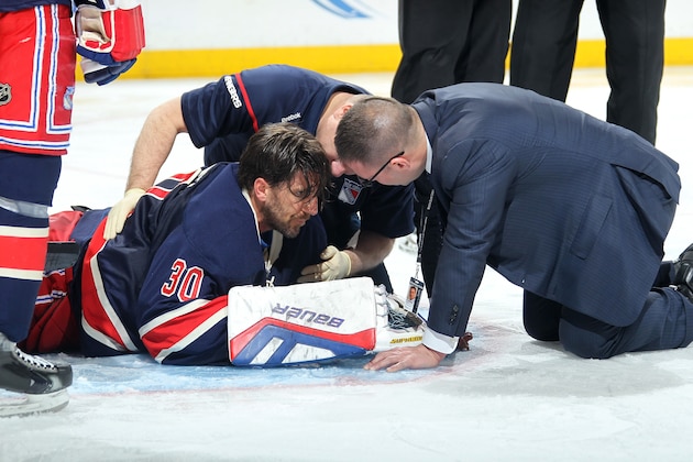 NEW YORK, NY - JANUARY 31:  Henrik Lundqvist #30 of the New York Rangers is attended to by members of the medical staff after being hit with a high stick against the Carolina Hurricanes at Madison Square Garden on January 31, 2015 in New York City. (Photo by Jared Silber/NHLI via Getty Images)