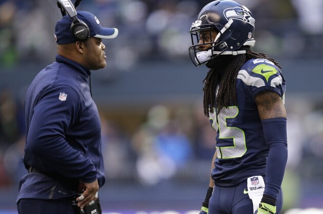 Seattle Seahawks cornerback Richard Sherman, right, talks with linebackers coach Ken Norton Jr. during an NFL football game against the St. Louis Rams, Sunday, Dec. 28, 2014, in Seattle. (AP Photo/Scott Eklund)