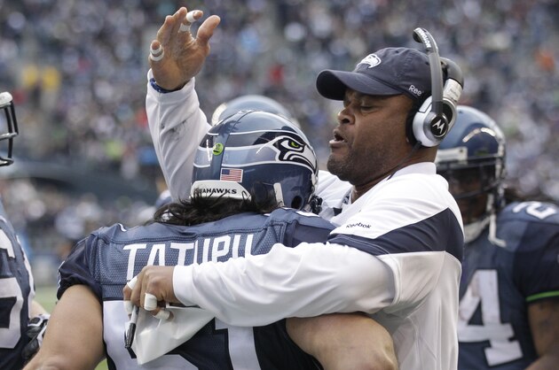 Seattle Seahawks linebackers coach Ken Norton Jr. greets Lofa Tatupu (51) and Mike Gibson (64) after a play against the Carolina Panthers in the second half of an NFL football game, Sunday, Dec. 5, 2010 in Seattle. (AP Photo/Ted S. Warren)