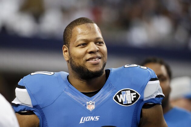 Detroit Lions' Ndamukong Suh smiles as he walks across the field during warm ups before an NFL football game against the Dallas Cowboys, Sunday, Jan. 4, 2015, in Arlington, Texas. (AP Photo/Tony Gutierrez)