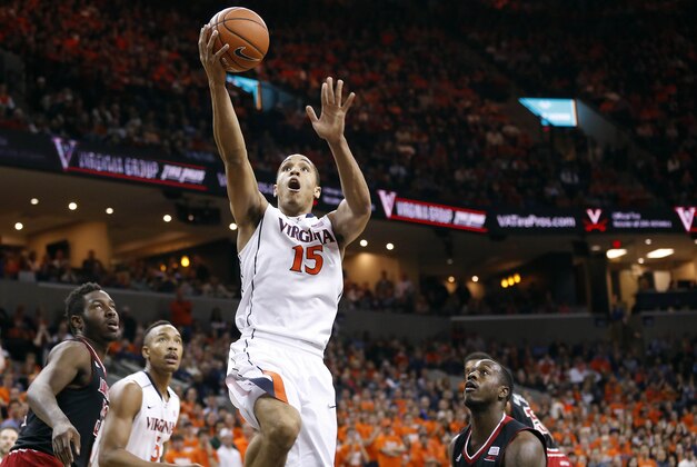 Feb 7, 2015; Charlottesville, VA, USA; Virginia Cavaliers guard Malcolm Brogdon (15) shoots the ball as Louisville Cardinals forward/center Chinanu Onuaku (32) looks on in the first half at John Paul Jones Arena. Mandatory Credit: Geoff Burke-USA TODAY Sports