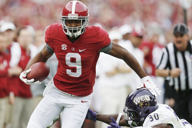 Alabama wide receiver Amari Cooper (9) avoids the tackle from Western Carolina defensive back A.J. McKoy (30) during the first half of an NCAA college football game, Saturday, Nov. 22, 2014, in Tuscaloosa, Ala. Cooper limped off the field after an injury on the play. (AP Photo/Brynn Anderson)
