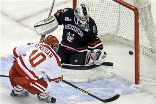 Boston forward Danny O'Regan (10) pokes the puck past Northeastern goalie Chris Rawlings for a goal during the first period of the opening round of the Beanpot college hockey tournament in Boston, Monday, Feb. 4, 2013. (AP Photo/Charles Krupa)