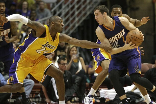 Los Angeles Lakers' Kobe Bryant, left, pressures Phoenix Suns' Goran Dragic, of Slovenia, during the first half of a preseason NBA basketball game on Tuesday, Oct. 21, 2014, in Anaheim, Calif. (AP Photo/Jae C. Hong)