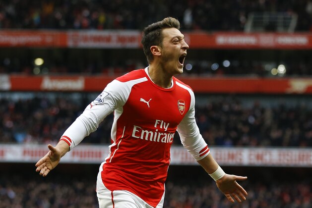 Arsenal's Mesut Ozil celebrates scoring a goal during the English Premier League soccer match between Arsenal and Aston Villa at the Emirates stadium in London, Sunday, Feb. 1, 2015. (AP Photo/Kirsty Wigglesworth)