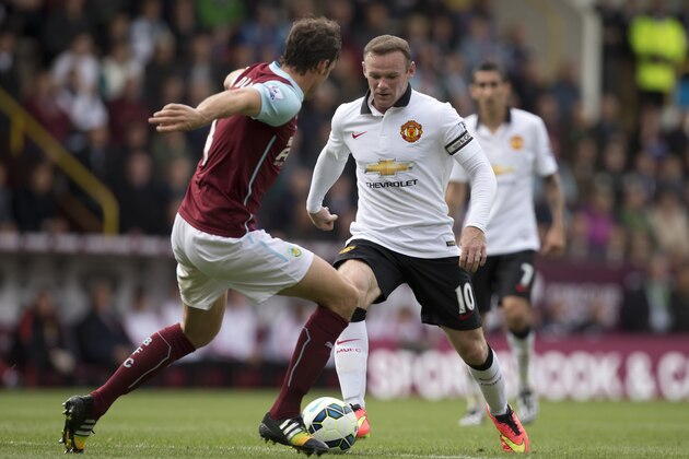 Manchester United's Wayne Rooney, center, keeps the ball from Burnley's Michael Duff during their English Premier League soccer match at Turf Moor Stadium, Burnley, England, Saturday Aug. 30, 2014. (AP Photo/Jon Super)