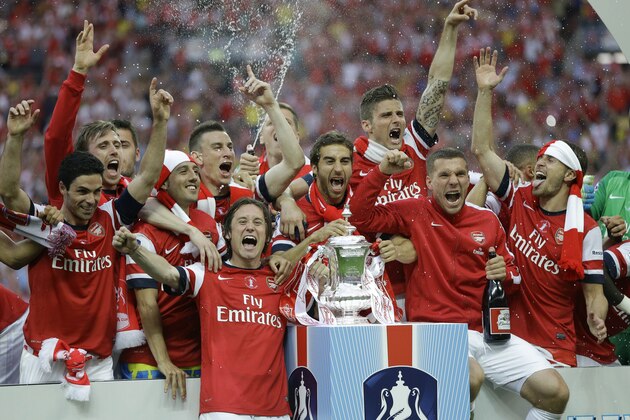 Arsenal players celebrate after winning the English FA Cup final soccer match between Arsenal and Hull City at Wembley Stadium in London, Saturday, May 17, 2014. Arsenal won 3-2 after extra-time. (AP Photo/Kirsty Wigglesworth)
