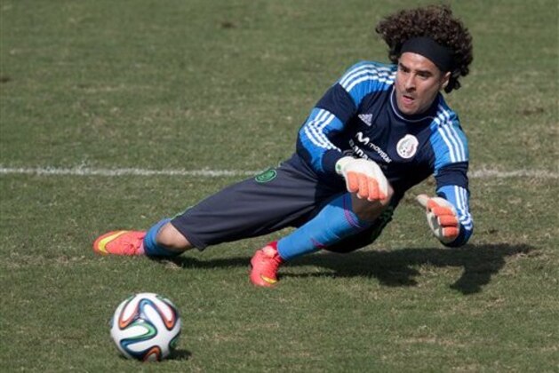 Mexico goalkeeper Guillermo Ochoa leaps to trap a ball during a training session in Santos, Brazil, Thursday, June 26, 2014. Mexico will face the Netherlands in their next World Cup match in Fortaleza, Sunday. (AP Photo/Eduardo Verdugo)
