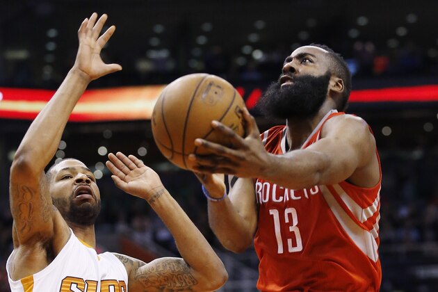 Houston Rockets' James Harden (13) drives past Phoenix Suns' Marcus Morris, left, during the first half of an NBA basketball game Tuesday, Feb. 10, 2015, in Phoenix. (AP Photo/Ross D. Franklin)