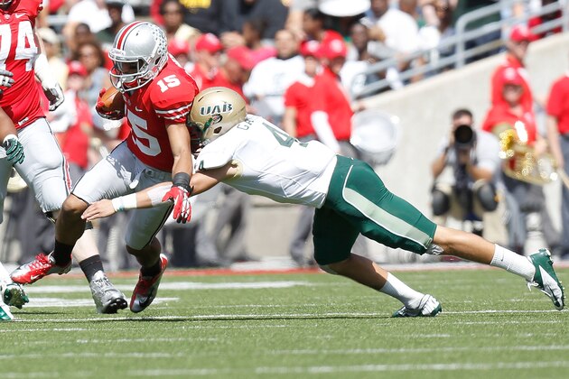 COLUMBUS, OH - SEPTEMBER 22:  Devin Smith #15 of the Ohio State Buckeyes is tackled by Jake Ganus #4 of the University of Alabama at Birmingham Blazers during the second quarter on September 22, 2012 at Ohio Stadium in Columbus, Ohio. (Photo by Kirk Irwin/Getty Images)