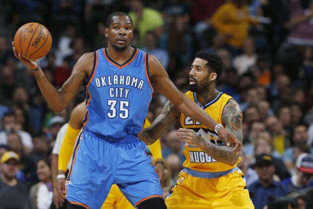 Oklahoma City Thunder forward Kevin Durant, left, looks to pass the ball as Denver Nuggets forward Wilson Chandler defends in the third quarter of an NBA basketball game Monday, Feb. 9, 2015, in Denver. The Thunder won 124-114. (AP Photo/David Zalubowski)
