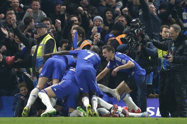 Chelsea's Willian is mobbed by teammates after scoring the only goal of the game during their English Premier League soccer match between Chelsea and Everton at Stamford Bridge stadium in London, Wednesday, Feb. 11, 2015. Chelsea won the match 1-0. (AP Photo/Alastair Grant)