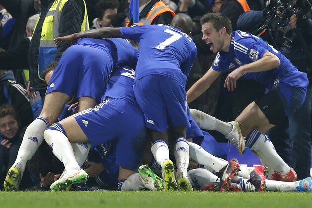 Chelsea's Willian is mobbed by teammates after scoring the only goal of the game during their English Premier League soccer match between Chelsea and Everton at Stamford Bridge stadium in London, Wednesday, Feb. 11, 2015. Chelsea won the match 1-0. (AP Photo/Alastair Grant)