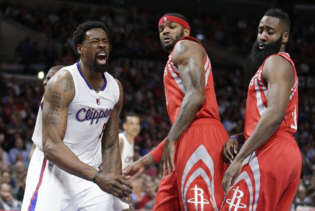Los Angeles Clippers' DeAndre Jordan, left, celebrates after making a basket as Houston Rockets' James Harden, right, and Josh Smith watch during the first half of an NBA basketball game, Wednesday, Feb. 11, 2015, in Los Angeles. (AP Photo/Jae C. Hong)