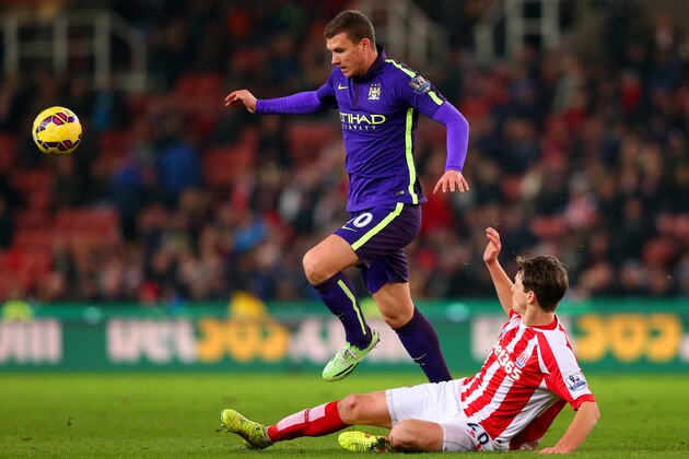 STOKE ON TRENT, ENGLAND - FEBRUARY 11:  Edin Dzeko of Manchester City jumps over a challenge from Philipp Wollscheid of Stoke City during the Barclays Premier League match between Stoke City and Manchester City at Britannia Stadium on February 11, 2015 in Stoke on Trent, England.  (Photo by Alex Livesey/Getty Images)