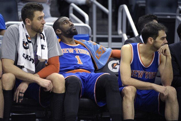 New York Knicks center Andrea Bargnani, left, center Amar'e Stoudemire (1) and guard Jose Calderon, right, watch from the bench during final seconds of the second half of an NBA basketball game against the Orlando Magic in Orlando, Fla., Wednesday, Feb. 11, 2015. The Magic won 89-83.(AP Photo/Phelan M. Ebenhack)