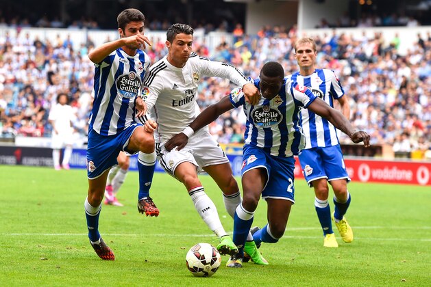 LA CORUNA, SPAIN - SEPTEMBER 20:  Cristiano Ronaldo of Real Madrid CF is brought down by Juan Dominguez (L) and Modibo Diakite of RC Deportivo of RC Deportivo La Coruna during the La Liga match between RC Deportivo La Coruna and Real Madrid CF at Riazor Stadium on September 20, 2014 in La Coruna, Spain.  (Photo by David Ramos/Getty Images)