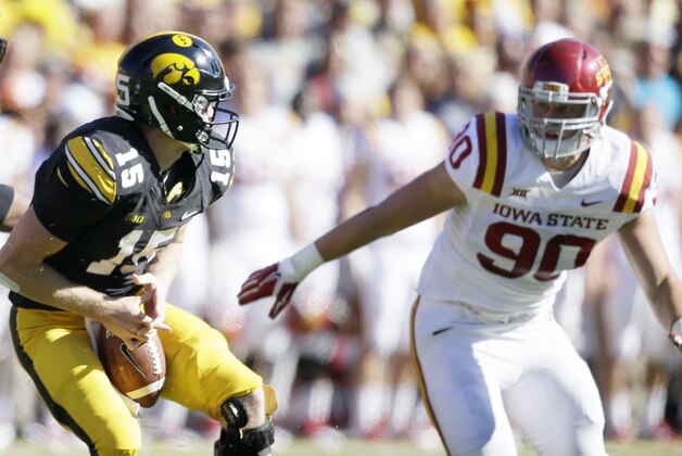 Iowa quarterback Jake Rudock, left, fumbles the ball in front of Iowa State defensive end Mitchell Meyers, right, during the first half of an NCAA college football game, Saturday, Sept. 13, 2014, in Iowa City, Iowa. Iowa State won 20-17. (AP Photo/Charlie Neibergall)