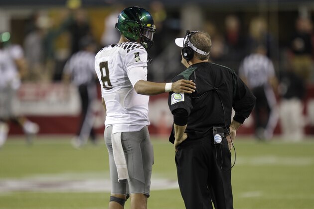 Oregon head coach Chip Kelly, right, talk with quarterback Marcus Mariota, left, during an NCAA college football game against Washington State, Saturday, Sept. 29, 2012, in Seattle. (AP Photo/Ted S. Warren)