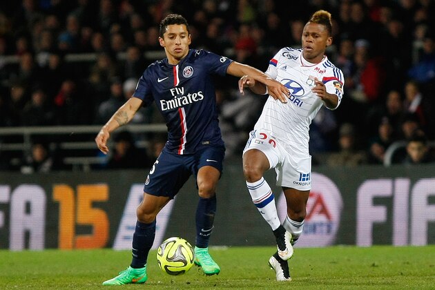 Paris Saint Germain's Brazilian defender Marquinhos, left, battles for the ball with Lyon's Cameroonian forward Clinton N'Jie during the League One soccer match between Lyon and Paris Saint-Germain, at the Gerland Stadium, in Lyon, central France, Sunday Feb. 8, 2015. (AP Photo/Claude Paris)