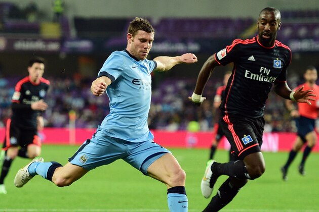 Manchester City's midfielder James Milner, left, shoots the ball under pressure of Hamburg defender Johan Djourou during a friendly match in Al Ain, United Arab Emirates, Wednesday, Jan. 21, 2015. (AP Photo/Said Khaled)