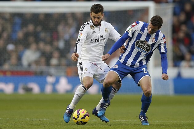 Real Madrid’s Nacho duels for the ball with Deportivo's Oriol Riera during a Spanish La Liga soccer match between Real Madrid and Deportivo La Coruna at the Santiago Bernabeu stadium in Madrid, Spain, Saturday, Feb. 14, 2015. (AP Photo/Daniel Ochoa de Olza)