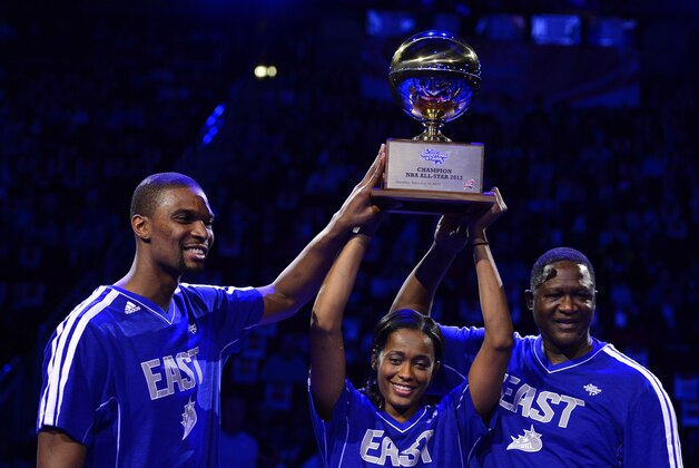Feb 16, 2013; Houston, TX, USA; Miami Heat player Chris Bosh (left) hoists the shooting stars trophy with Chicago Sky player Swin Cash (middle) and Atlanta Hawks former player Dominique Wilkins (right) after the 2013 NBA All-Star shooting stars competition at the Toyota Center. Mandatory Credit: Bob Donnan-USA TODAY Sports