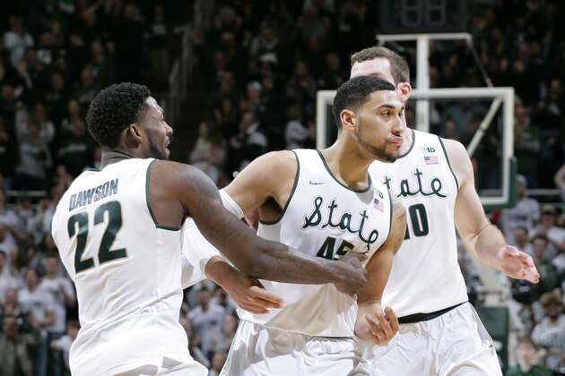 Michigan State's Branden Dawson (22), Denzel Valentine, center, and Matt Costello, rear, celebrate after Valentine hit a 3-pointer with 3.2 seconds remaining during the second half of an NCAA college basketball game against Ohio state, Saturday, Feb. 14, 2015, in East Lansing, Mich. Michigan State won 59-56. (AP Photo/Al Goldis)