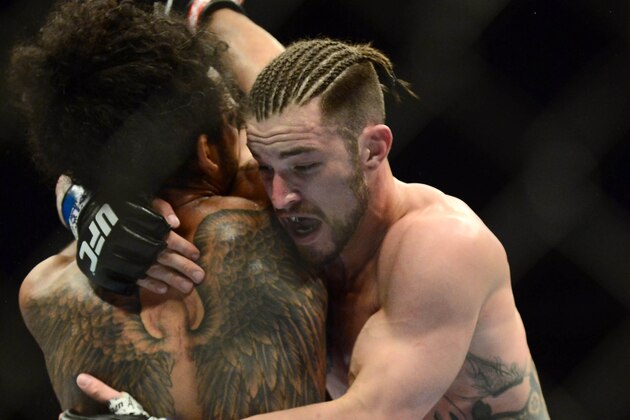 Feb 14, 2015; Broomfield, CO, USA; Brandon Thatch (blue) and Benson Henderson (red) compete in the welterweight bout at the UFC Fight Night at the 1stBANK Center. Mandatory Credit: Ron Chenoy-USA TODAY Sports