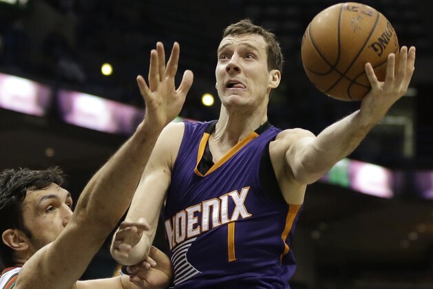 Phoenix Suns' Goran Dragic attempts a layup over Milwaukee Bucks' Zaza Pachulia during an NBA basketball game Tuesday, Jan. 6, 2015, in Milwaukee. (AP Photo/Aaron Gash)
