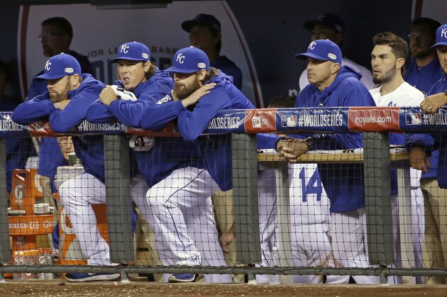 Kansas City Royals players watch from the dugout as San Francisco Giants players celebrates after Game 7 of baseball's World Series Wednesday, Oct. 29, 2014, in Kansas City, Mo. The Giants won 3-2 to win the series.   (AP Photo/Matt Slocum)