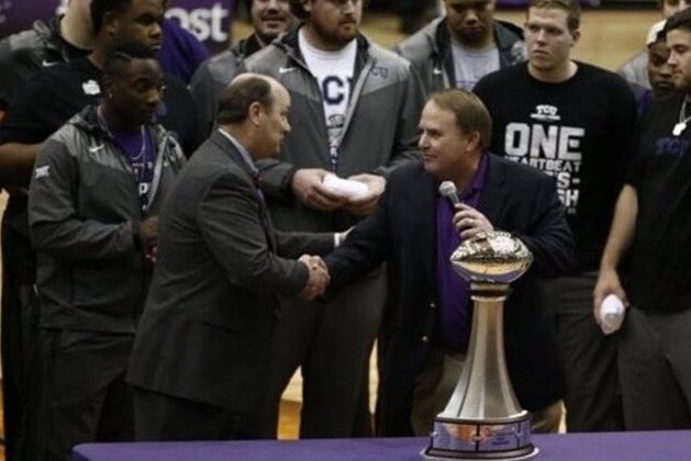 TCU football teammates look on as head coach Gary Patterson, right, is congratulated by Chick-fil-A Peach Bowl CEO Gary Stokan, left, in a trophy ceremony  during halftime of an NCAA basketball game between Texas and TCU, Monday, Jan. 19, 2015, in Fort Worth. Texas  won 66-48. (AP Photo/Jim Cowsert)