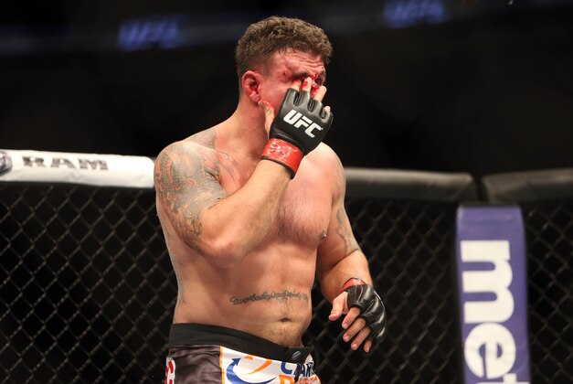 Feb 1, 2014; Newark, NJ, USA; Frank Mir (red gloves) wipes blood from his eye during his fight against Alistair Overeem (blue gloves) during UFC169 at Prudential Center. Mandatory Credit: Joe Camporeale-USA TODAY Sports