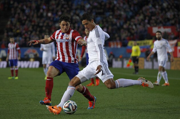 Real's Raphael Varane in action with Atletico's Cristian Rodriguez during a semi final, 2nd leg, Copa del Rey soccer derby match between Real Madrid and Atletico Madrid at the Vicente Calderon Stadium in Madrid, Tuesday Feb. 11 , 2014.  (AP Photo/Gabriel Pecot)