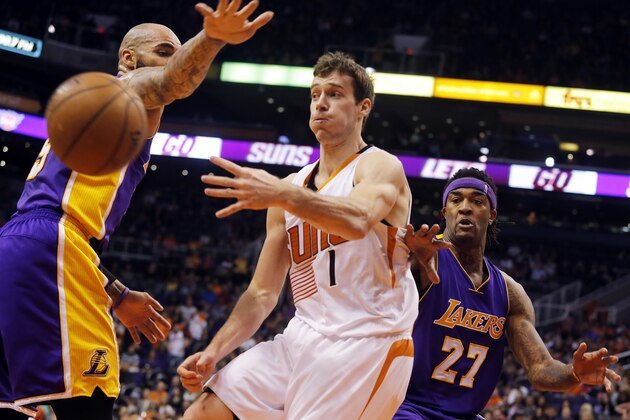 Phoenix Suns guard Goran Dragic (1) makes the pass between Los Angeles Lakers forward Carlos Boozer (5) and Jordan Hill (27) in the third quarter during an NBA basketball game, Monday, Jan. 19, 2015, in Phoenix. (AP Photo/Rick Scuteri)