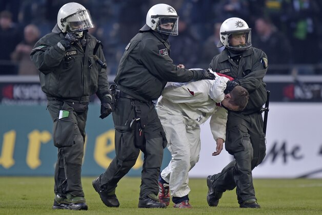 Police arrest a Cologne fan after they stormed the pitch after the German Bundesliga soccer match between Borussia Moenchengladbach and 1. FC Cologne in Moenchengladbach, Germany, Saturday, Feb. 14, 2015. Moenchengladbach defeated Cologne in overtime with 1-0. (AP Photo/Martin Meissner) Police arrest a Cologne fan after they stormed the pitch after the German Bundesliga soccer match between Borussia Moenchengladbach and 1. FC Cologne in Moenchengladbach, Germany, Saturday, Feb. 14, 2015. Moenchengladbach defeated Cologne in overtime with 1-0. (AP Photo/Martin Meissner)